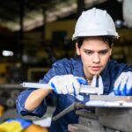 Female worker with safety hard hat working at manufacturing